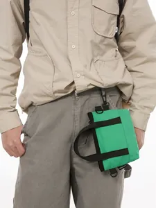 Bright green mini nylon crossbody bag with black handles and top carabiner clip