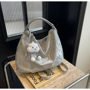 Détail du sac cabas gris argenté avec motif marbré, breloque nuage et bandoulière amovible
