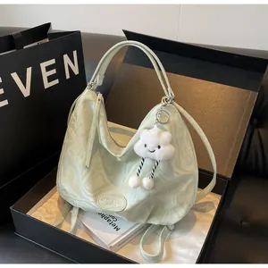 Détail du sac fourre-tout vert clair à motif marbré avec pendentif nuage en peluche