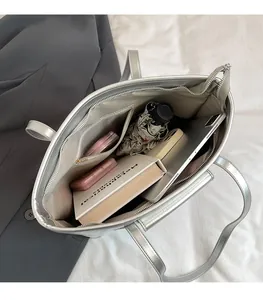 Interior view of silver metallic tote bag showing large capacity and multi-pocket design