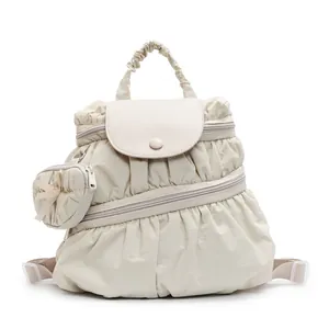 Chic beige ruched nylon backpack with drawstring handle and matching bow pendant charm