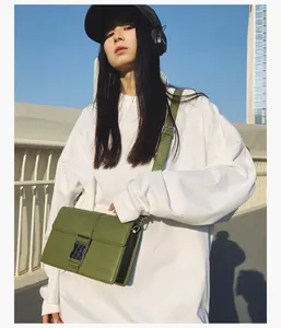 Close-up of a dark green leather crossbody bag with silver buckle and logo detail