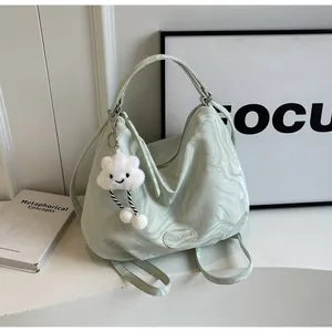 Détail du sac cabas marbré vert menthe avec logo de marque et pendentif nuage en peluche