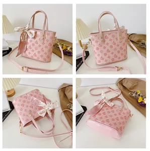 Detailansicht der rosa Ledertasche mit Logo-Muster, Seidentuch und abnehmbarem Gurt