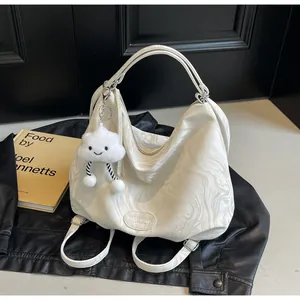 Détail du sac cabas à motif marbre blanc avec étiquette en cuir et charme nuage