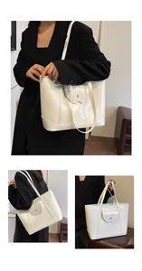Close-up of a white patent leather tote bag featuring decorative flap and dual slim straps