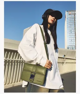 Close-up of olive green leather crossbody bag featuring silver buckle and FLOWERBAG logo