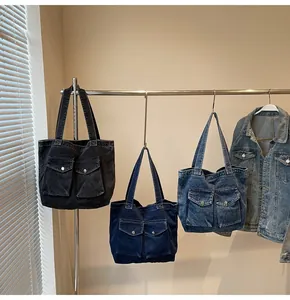 Trois cabas en jean noir, bleu foncé et bleu clair avec doubles poches avant