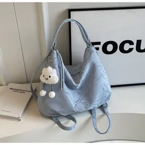 Détail du cabas bleu clair à motif marbré avec un pendentif nuage en peluche douce