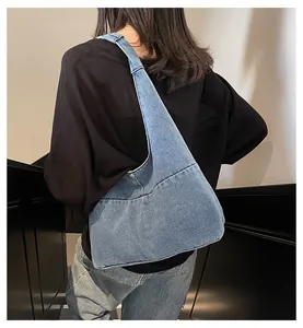 Detailed back view of a light blue washed denim hobo bag on shoulder for casual style
