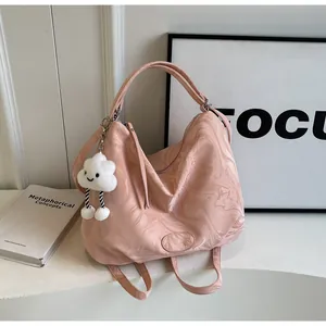 Détail d'un cabas rose motif marbre avec écusson logo en cuir et accessoire de nuage