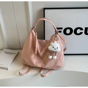 Détail du sac à main rose marbré avec un pendentif nuage et une sangle réglable