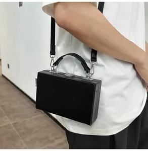 Detail of a black matte hardshell box bag featuring silver metal buckle and reinforced handle