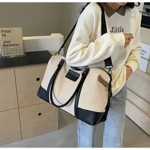 Detail of canvas travel tote with leather trim and wide adjustable shoulder strap