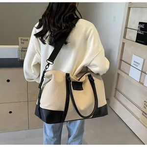 Detail of canvas travel bag with black leather trim and adjustable shoulder strap