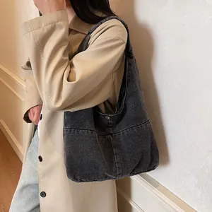 Chic dark grey denim hobo bag featuring a spacious interior and casual retro style