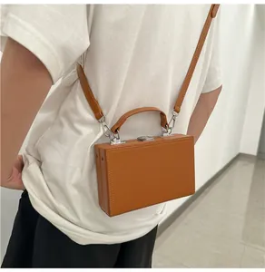Detail view of a vintage brown leather box bag with fine stitching and metal buckles