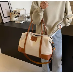 Detail view of large canvas travel bag with leather straps on a cafe bar background