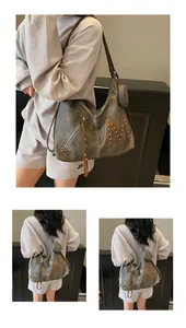 Detailed view of grey soft leather tote bag featuring rivet M logo and zipper accents