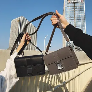 Minimalist square flap crossbody bag in black and mocha gray with metal buckle closure