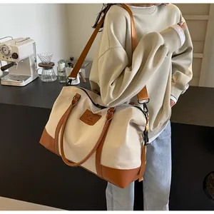 Detail of canvas travel bag with leather trim and BAIGETI FASHION letter patch