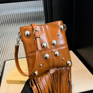 Bolso bandolera de cuero marrón con remaches plateados y diseño de flecos largos