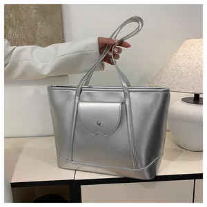 Detailed view of silver metallic tote bag with textured surface and front buckled pocket