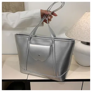 Detailed view of silver metallic tote bag with front flap pocket and dual handles