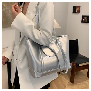Silver large capacity tote bag worn by a model in a stylish white blazer outfit