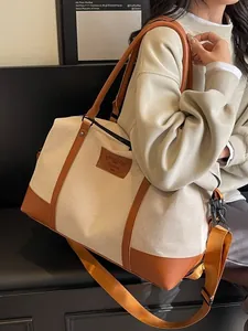 Large beige canvas travel bag with brown leather trim and adjustable shoulder strap