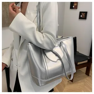 Detail of silver metallic tote bag with unique wave-edge pocket and sleek metal lock