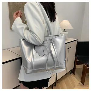 Silver metallic tote bag on model's shoulder showing minimalist design and spacious capacity