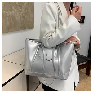 Metallic silver tote bag detail with slim shoulder straps and a central buckle accent