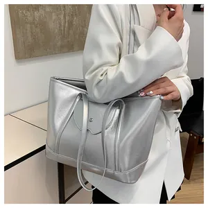 Close-up of metallic silver tote bag with magnetic flap and stitching details