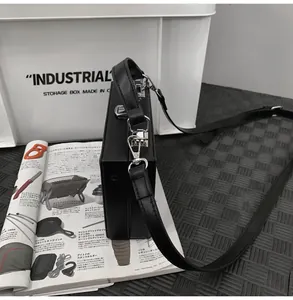 Detail view of the black box bag showing silver metal clasp and matte leather texture