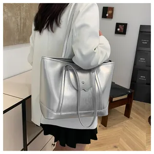 Detail view of large silver tote bag with metallic finish and unique wavy edge detail