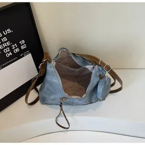 Internal view of blue denim tote bag with brown leather straps and branded lining
