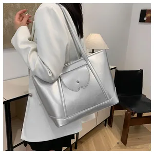 Chic silver tote bag detail featuring a front flap pocket and sturdy shoulder straps