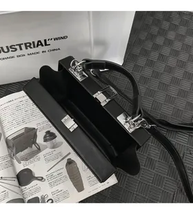 Interior view of black hard shell crossbody box bag with silver metal lock closure