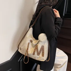 Chic beige tote bag with large M rivet design and matching round coin purse detail