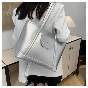 Detail of silver metallic tote bag featuring textured leather and unique flap pocket