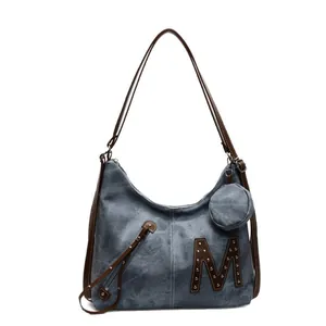 Retro biker style large blue tote bag with a brown leather letter M and metal rivets