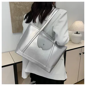 Detailed back view of a silver tote bag with metallic texture on a female model