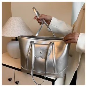 Close-up of metallic silver tote bag texture with magnetic pocket and buckle detail