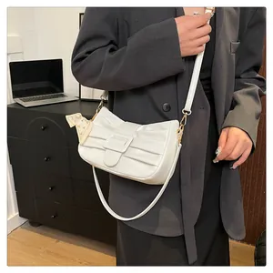 Détail du sac à bandoulière blanc plissé avec boucle carrée et foulard en soie décoratif
