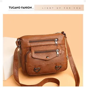 Detail of vintage brown textured leather crossbody bag with multiple zip pockets