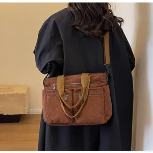 Rear view of brown corduroy tote bag with large zipper pockets and adjustable strap
