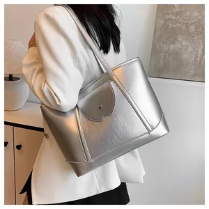 Close-up of metallic silver tote bag featuring pleated texture and front pocket with buckle