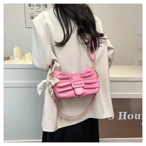 Détail d'un sac à main plissé rose orné d'un foulard floral et d'une boucle carrée élégante