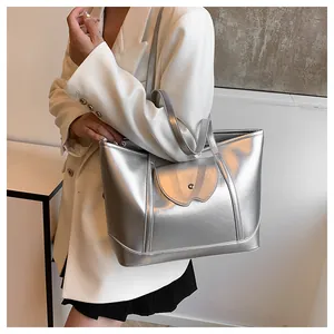 Detailed view of silver metallic tote bag featuring snap button pocket and reinforced base